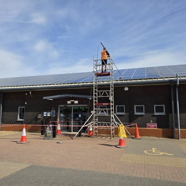 A worker cleaning Solar Panel Exterior to remove moss and algae in its cracks and make it look sparkling clean